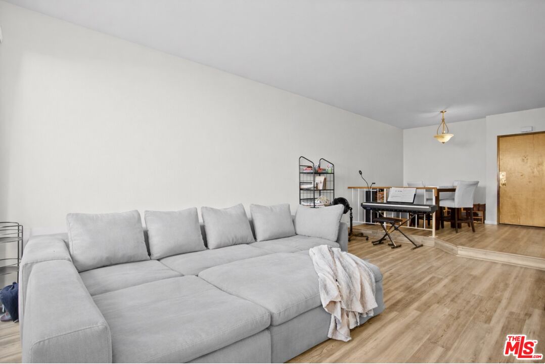 19009 Sherman Way, Unit 2 Reseda, CA 91335 - Photo 2 of 31 a living room with furniture and a dining table with wooden floor