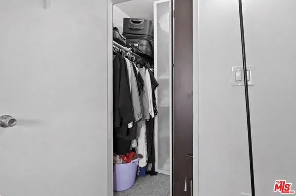 a view of walk in closet with clothes
