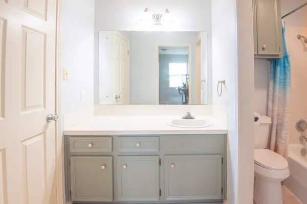 a bathroom with a sink a toilet and a mirror