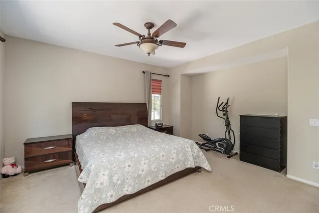 a bedroom with a bed and a ceiling fan