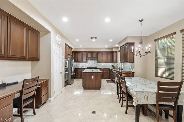 a kitchen with a dining table chairs and refrigerator
