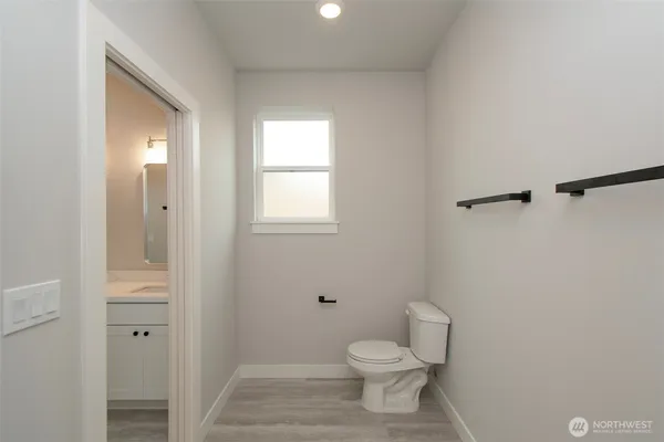 a bathroom with a granite countertop toilet a sink and a mirror