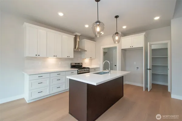a kitchen with a stove a refrigerator a sink and chairs