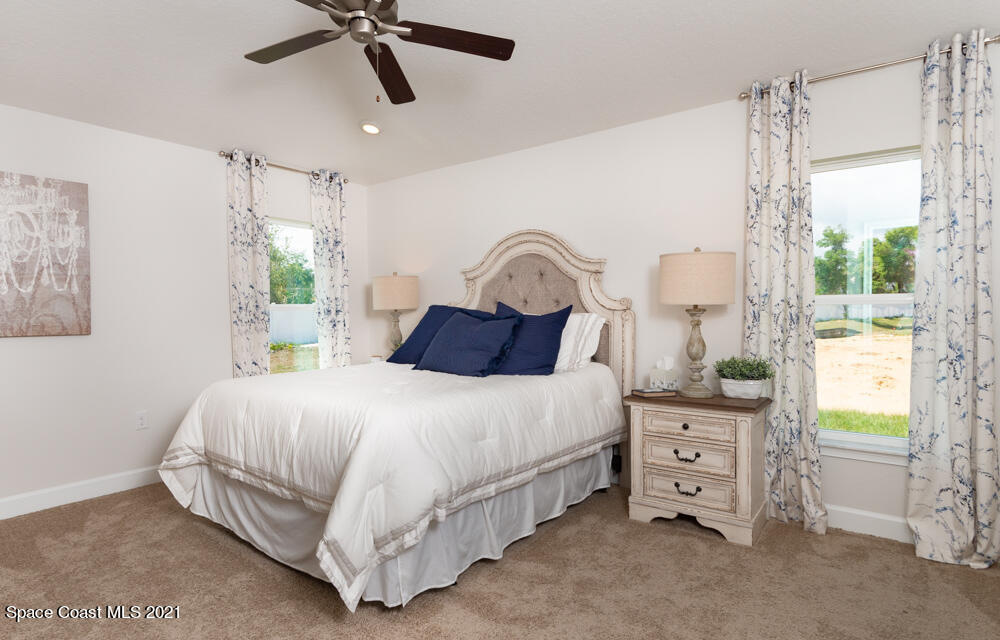 991 Tupelo Circle Cocoa, FL 32926 - Photo 12 of 23 a bedroom with a bed a chandelier and a window