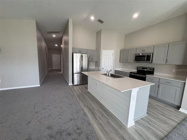 a kitchen with stainless steel appliances a refrigerator stove microwave and sink