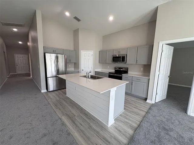 a kitchen with a sink a microwave a stove and refrigerator