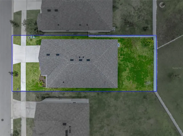 an aerial view of a house with garden space and ocean view