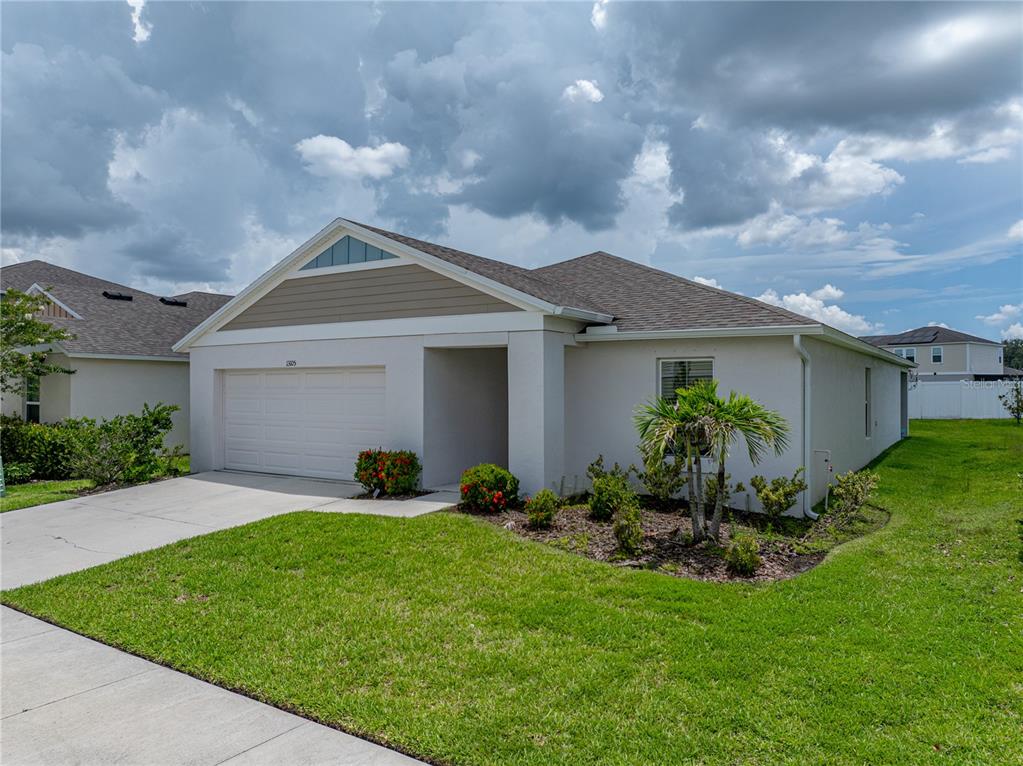 13105 Fruitville Way Riverview, FL 33579 - Photo 4 of 56 a front view of a house with a garden and plants