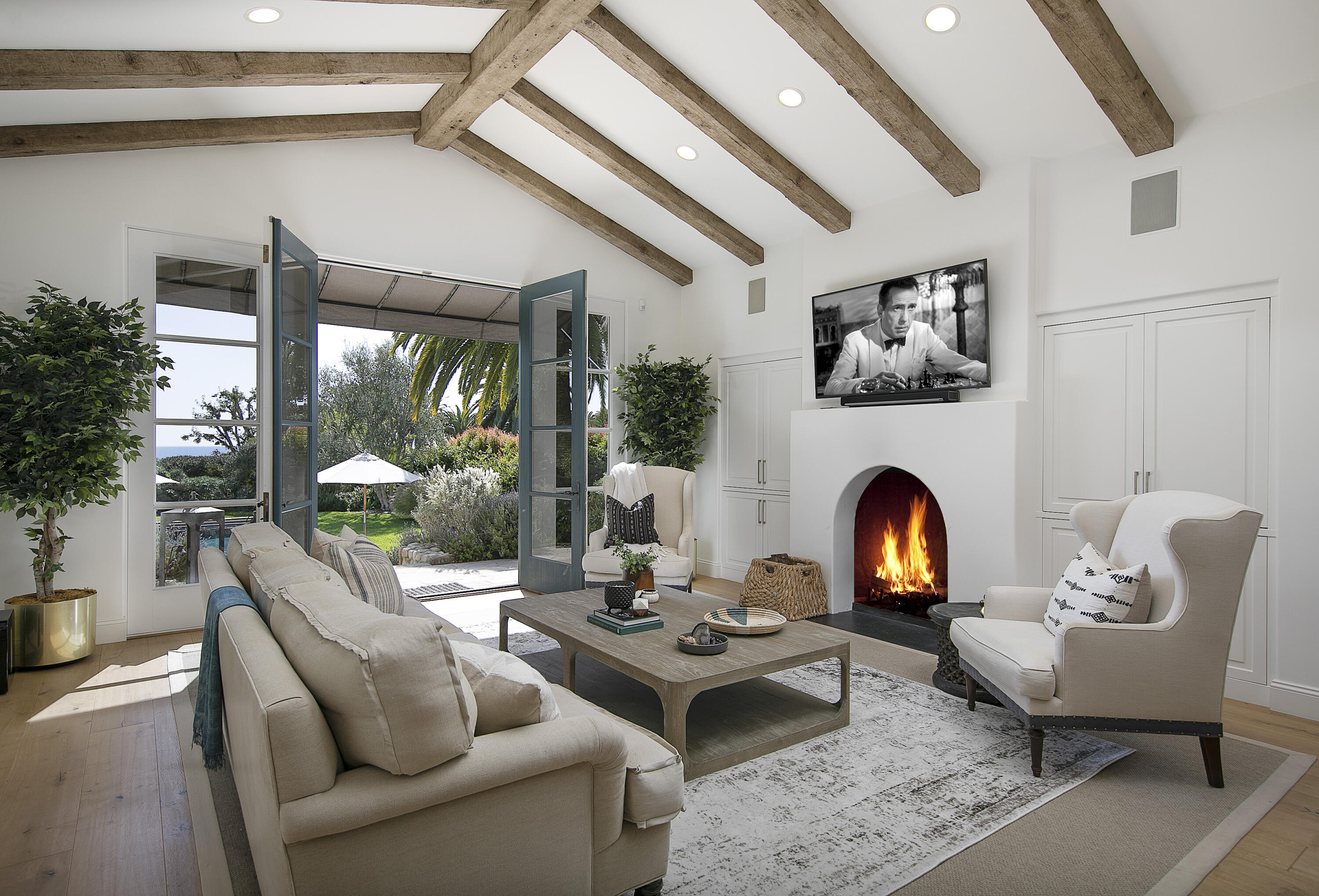 4110 Creciente Drive Santa Barbara, CA 93110 - Photo 13 of 27 a living room with furniture a fireplace and potted plants with wooden floor