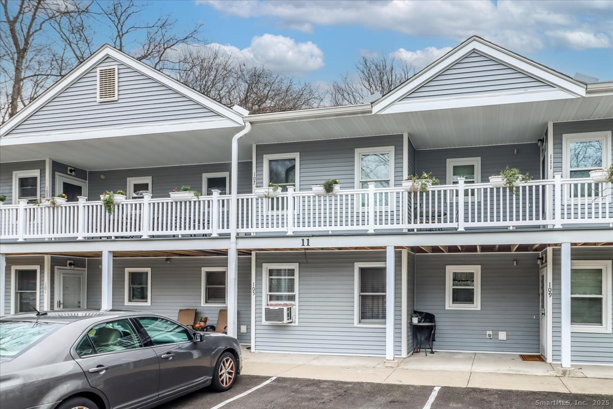 a view of a white house with large windows and a roof deck