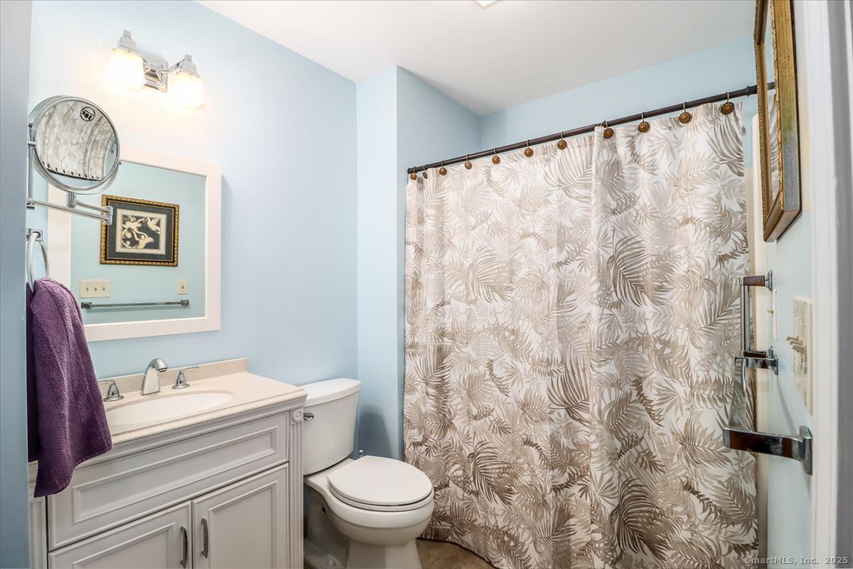 107 Hidden Knolls Circle, Unit 107 Monroe, CT 06468 - Photo 22 of 31 a bathroom with a toilet a sink and a shower curtain