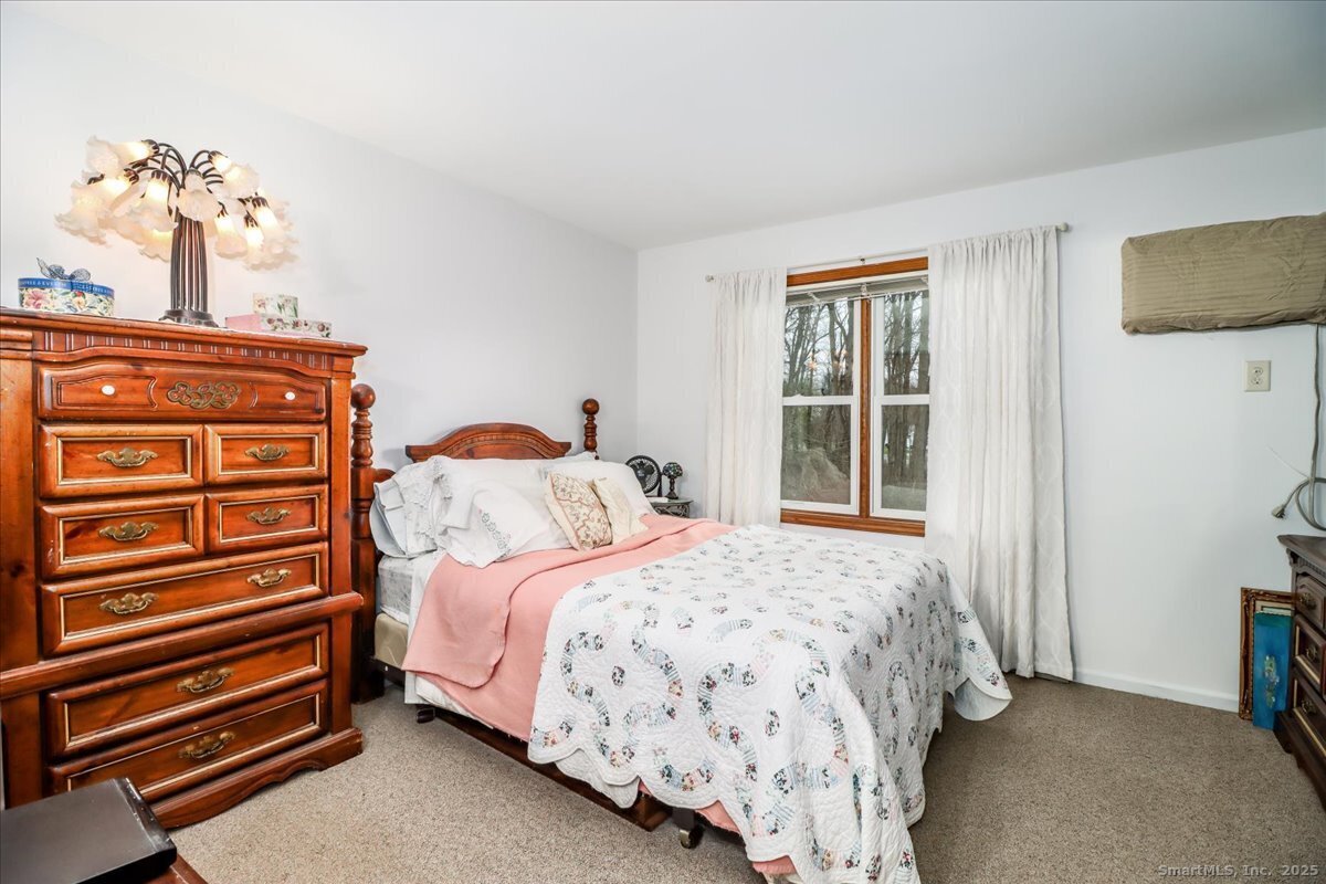 107 Hidden Knolls Circle, Unit 107 Monroe, CT 06468 - Photo 23 of 31 a bedroom with a bed and dresser with mirror