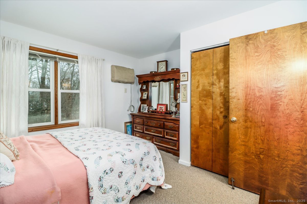 107 Hidden Knolls Circle, Unit 107 Monroe, CT 06468 - Photo 24 of 31 a bedroom with a bed and wooden floor