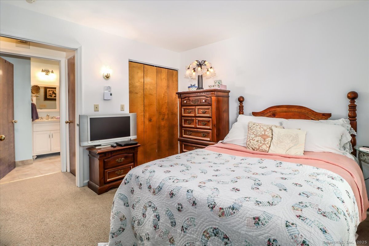 107 Hidden Knolls Circle, Unit 107 Monroe, CT 06468 - Photo 25 of 31 a bedroom with a bed and a television