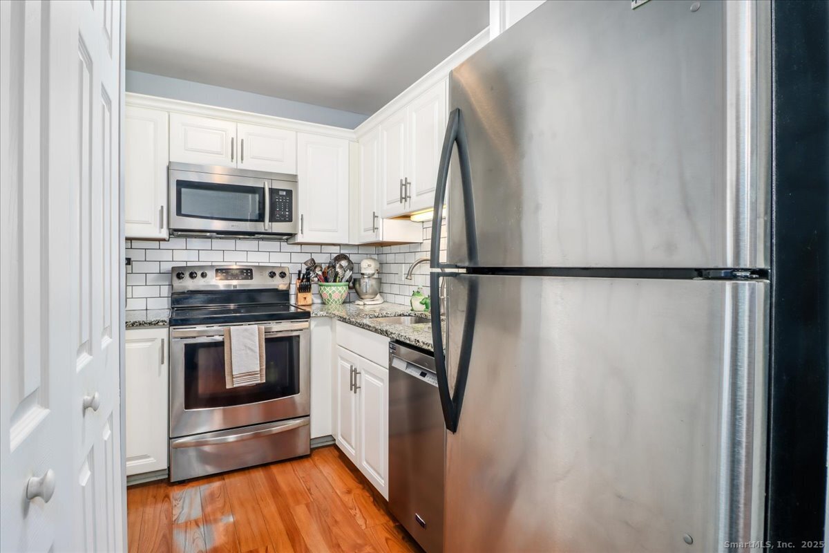 107 Hidden Knolls Circle, Unit 107 Monroe, CT 06468 - Photo 6 of 31 a kitchen with stainless steel appliances a refrigerator stove and microwave