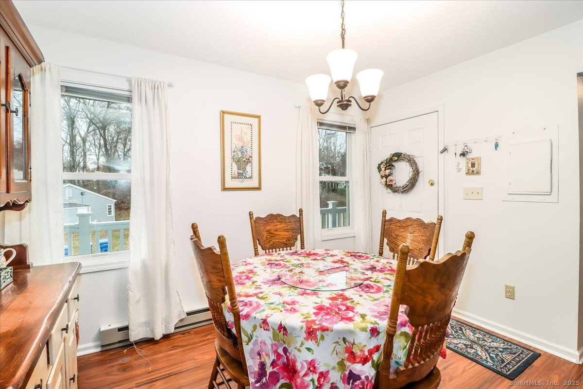 107 Hidden Knolls Circle, Unit 107 Monroe, CT 06468 - Photo 9 of 31 a view of a dining room with furniture a chandelier and wooden floor