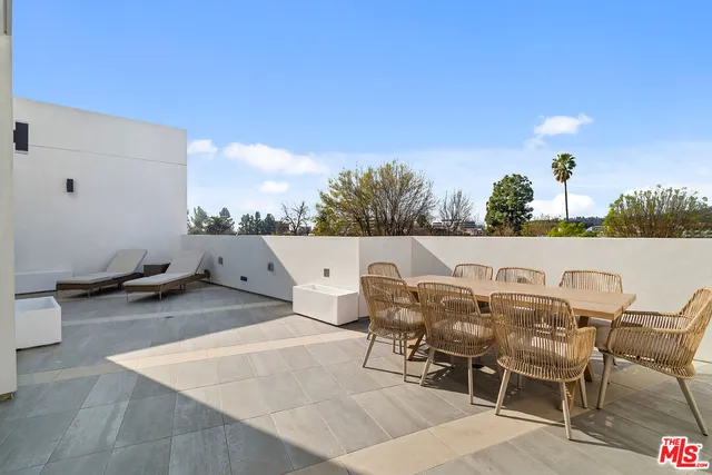a terrace with outdoor seating and trees