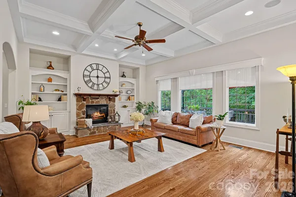 a living room with furniture a fireplace and a large window
