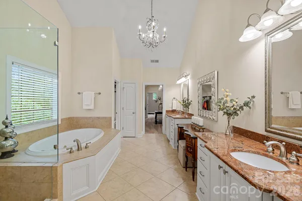 a spacious bathroom with a granite countertop tub sink and mirror