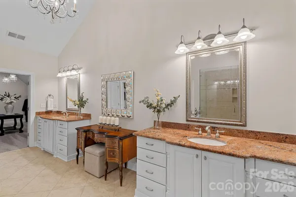 a spacious bathroom with a double vanity sink a mirror and a bathtub