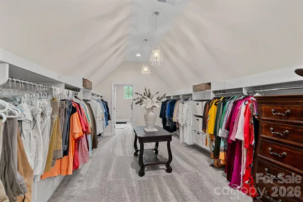 a view of walk in closet with clothes and shoes