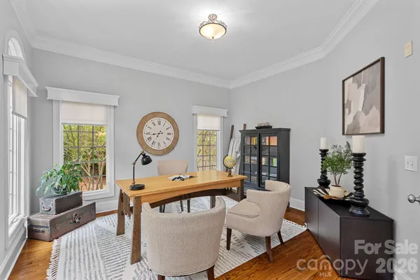 a living room with furniture a clock and wooden floor