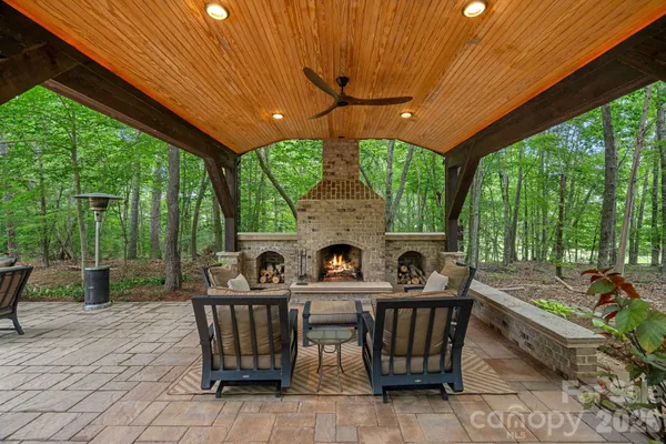 a view of a chairs and table in the patio next to a yard
