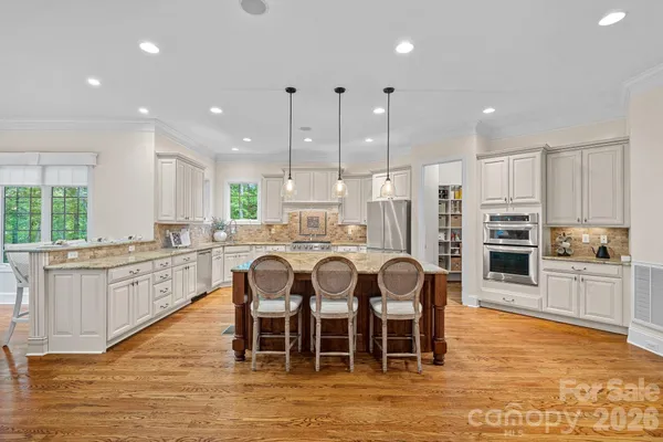 a large kitchen with kitchen island granite countertop a large center island and stainless steel appliances