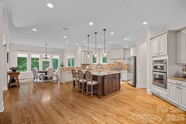 a kitchen with stainless steel appliances kitchen island granite countertop a large center island and a refrigerator