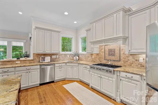 a kitchen with stainless steel appliances granite countertop a sink and cabinets