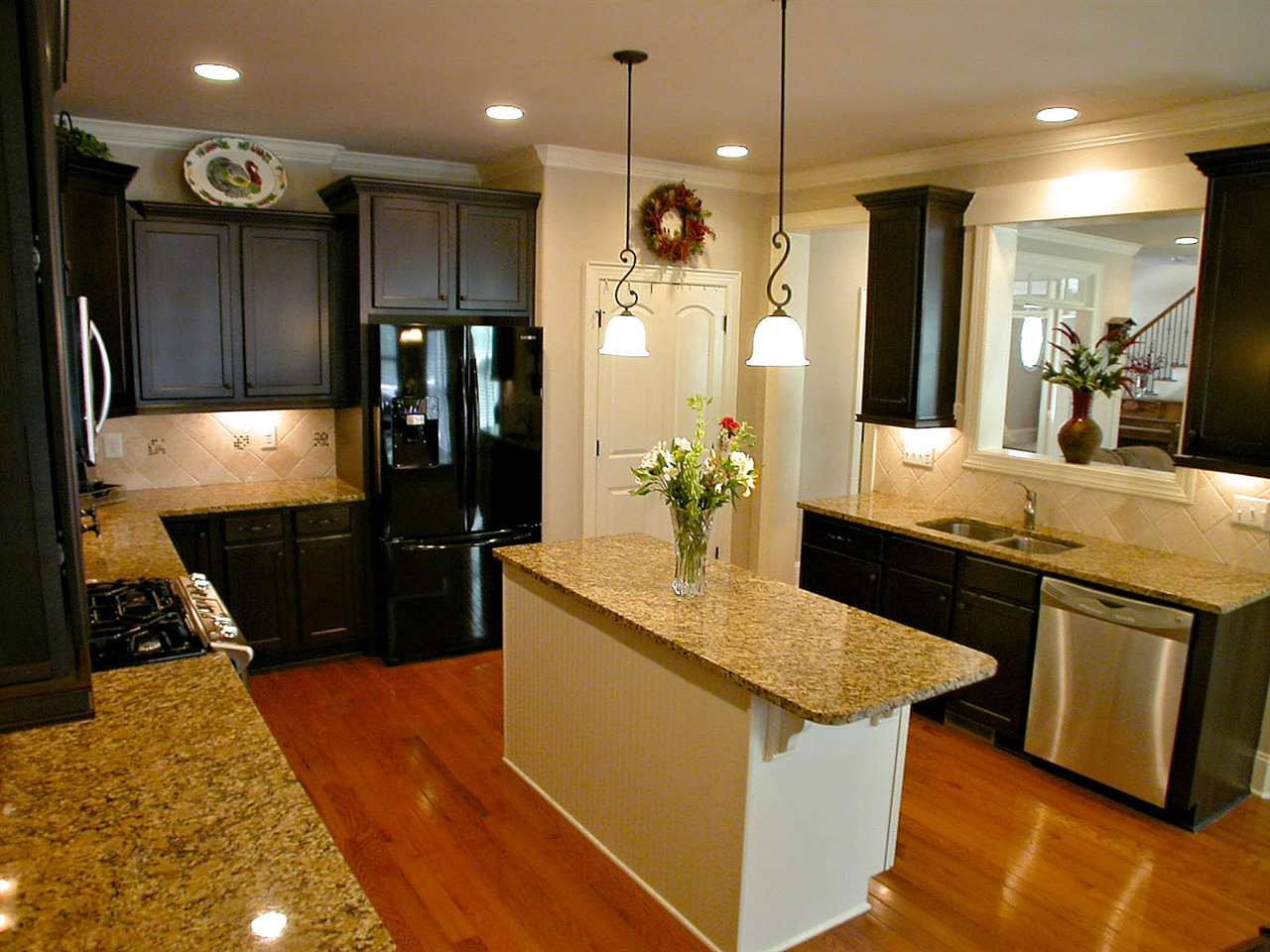 12349 Beestone Lane Raleigh, NC 27614 - Photo 8 of 25 Kitchen boasts stainless steel gas range, granite counter tops & island, custom cabinets with under cabinet lighting & double door pantry. Kitchen