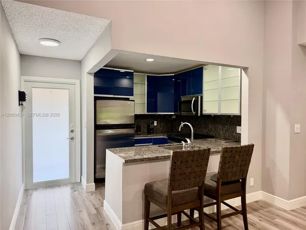 a kitchen with a refrigerator a stove a sink cabinets and wooden floor