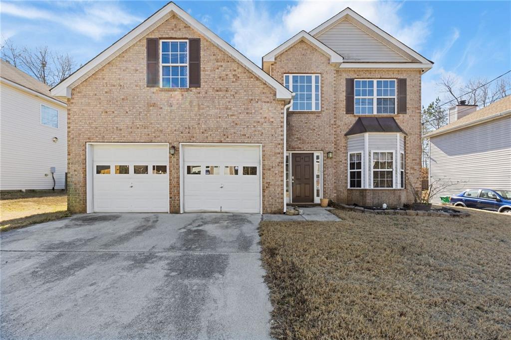a front view of a house with a yard and garage
