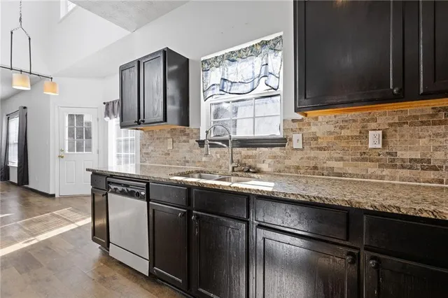 a kitchen with stainless steel appliances granite countertop a sink stove and cabinets