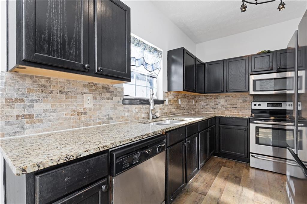 7035 Red Maple Lane Lithonia, GA 30058 - Photo 14 of 37 a kitchen with granite countertop stainless steel appliances and cabinets