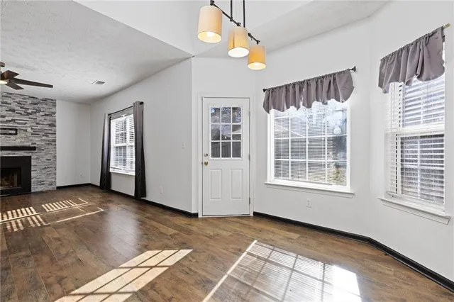 a view of an empty room with window and fireplace