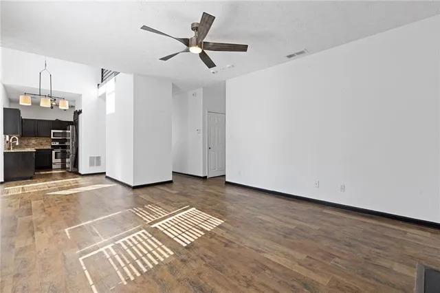 a view of a livingroom with wooden floor and a ceiling fan