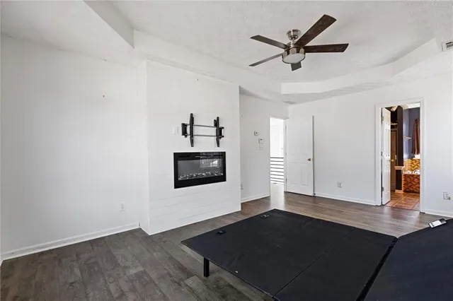 a view of a livingroom with wooden floor and a ceiling fan