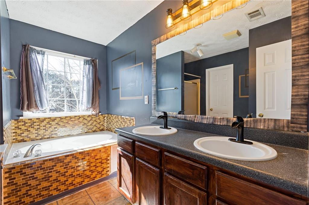 7035 Red Maple Lane Lithonia, GA 30058 - Photo 23 of 37 a bathroom with a granite countertop sink and a large mirror
