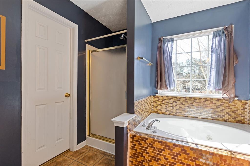 7035 Red Maple Lane Lithonia, GA 30058 - Photo 24 of 37 a bathroom with a tub and shower