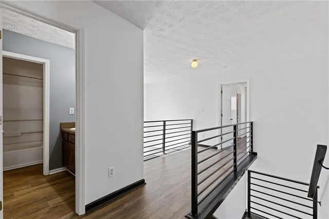 a view of a hallway with wooden floor and stairs