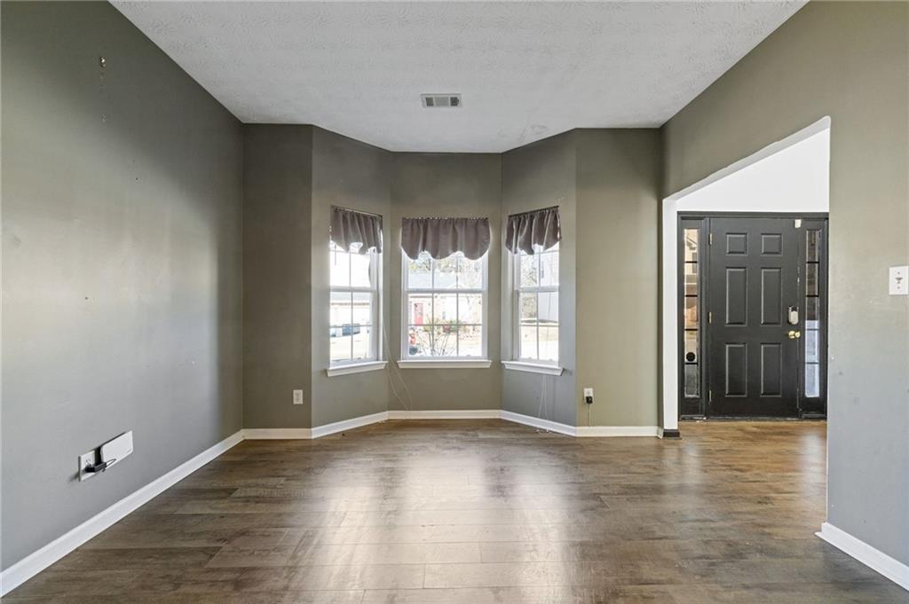 7035 Red Maple Lane Lithonia, GA 30058 - Photo 8 of 37 a view of an empty room with window and wooden floor