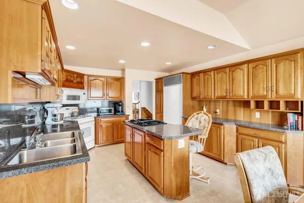 a kitchen with stainless steel appliances granite countertop sink stove and large window