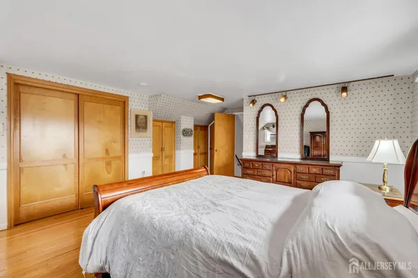 a bedroom with a large bed and wooden floor