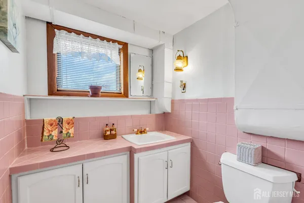 a bathroom with a sink mirror vanity and toilet