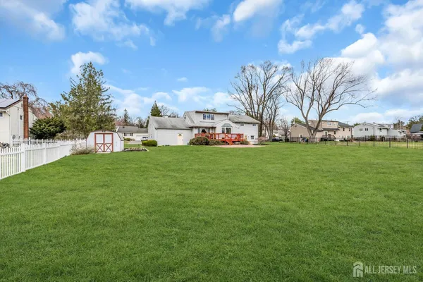 a view of a house with a big yard and large trees
