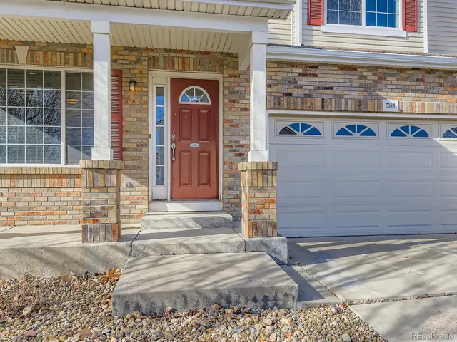 a front view of a house with a garage and large window