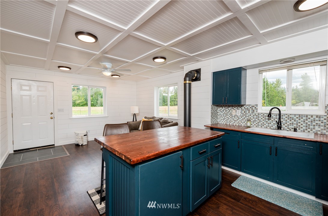 6565 Old Guide Road Bellingham, WA 98226 - Photo 24 of 27 a kitchen with stainless steel appliances granite countertop a sink a stove and a wooden floors