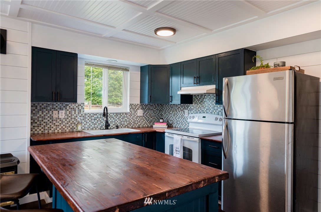 6565 Old Guide Road Bellingham, WA 98226 - Photo 25 of 27 a kitchen with stainless steel appliances granite countertop a refrigerator a sink a stove a dining table and chairs