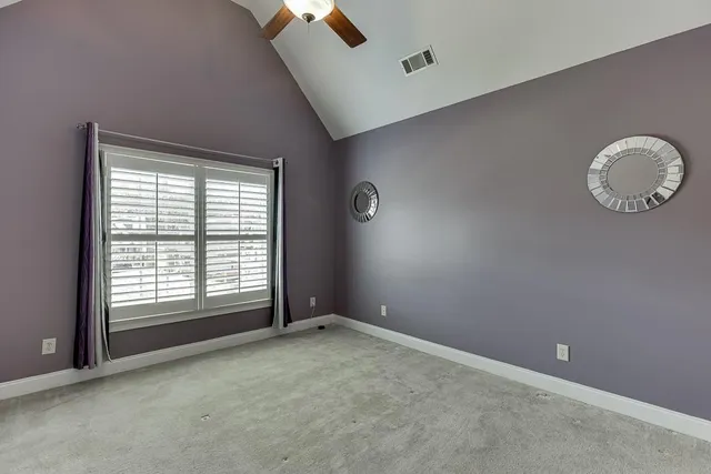 a bedroom with a bed a flat screen tv and a large window